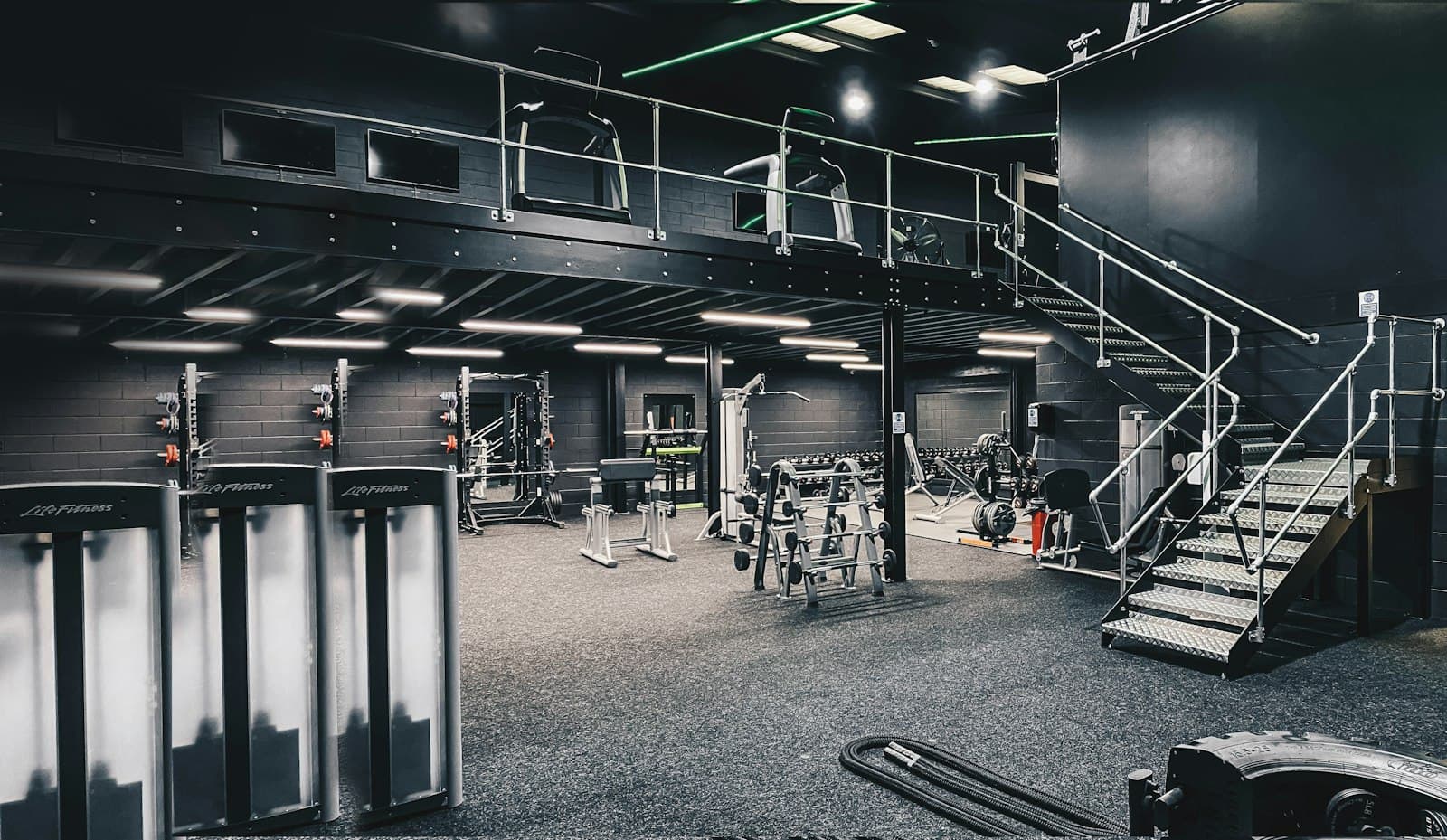 Gimnasio equipado con máquinas de fuerza, cardio y zona de peso libre